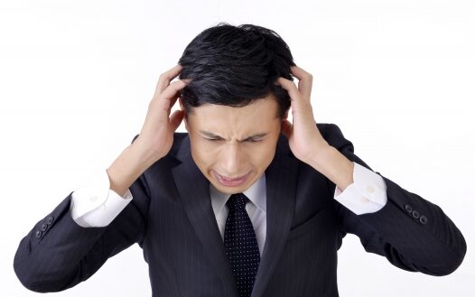 頭痛の症状でデスクワークの仕事がはかどらない40代男性
